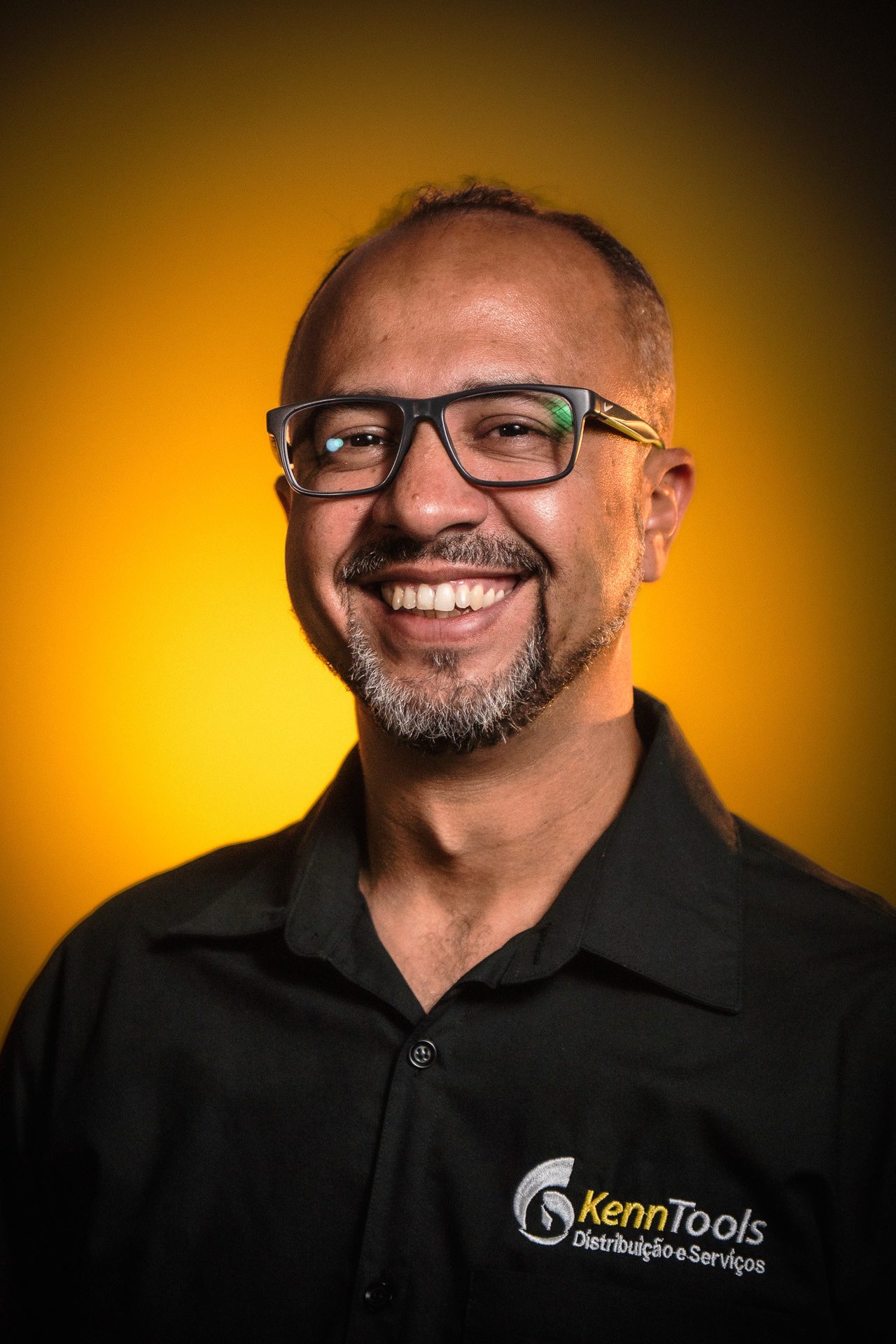 Retrato de representante comercial da KennTools com identidade visual da marca em fundo escuro e luz âmbar